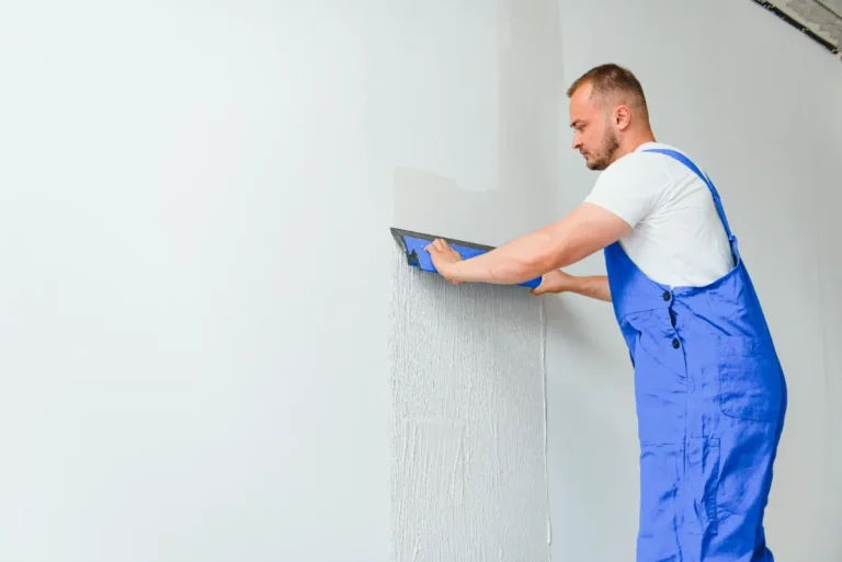 A worker carefully finishing the drywall.